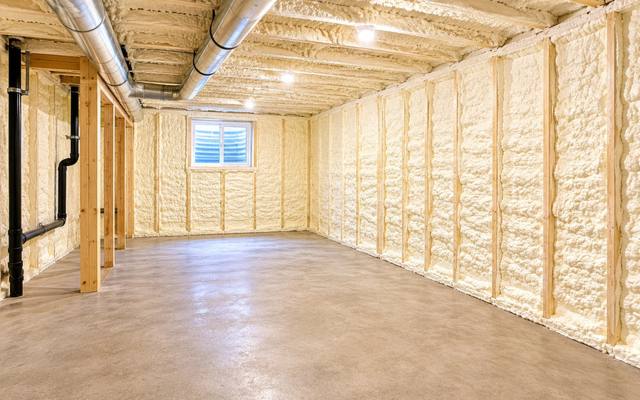 Unfinished basement with every foundation wall sprayed with foam